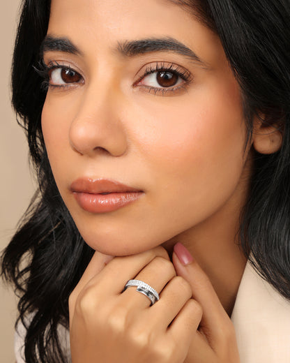 Woman wearing a Nadora Nove pavé diamond band ring, hands resting under her chin