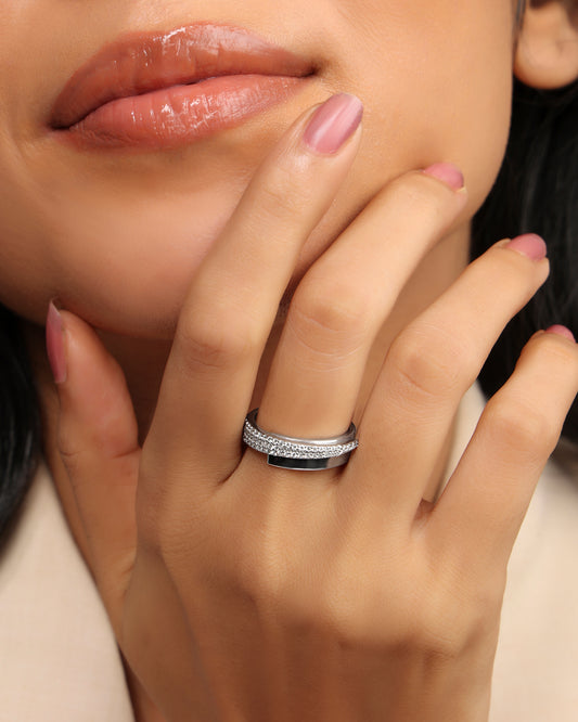 Woman wearing a Nadora Nove pavé diamond band ring with a black inlay, hand resting on her chin