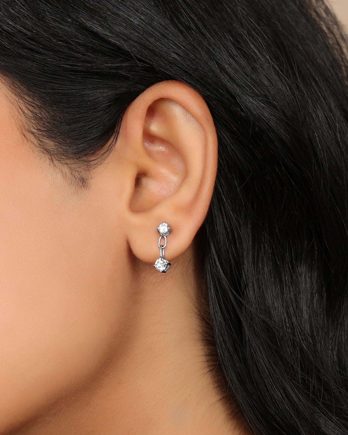 Woman wearing a Nadora Nove double diamond drop earring with two round prong-set stones