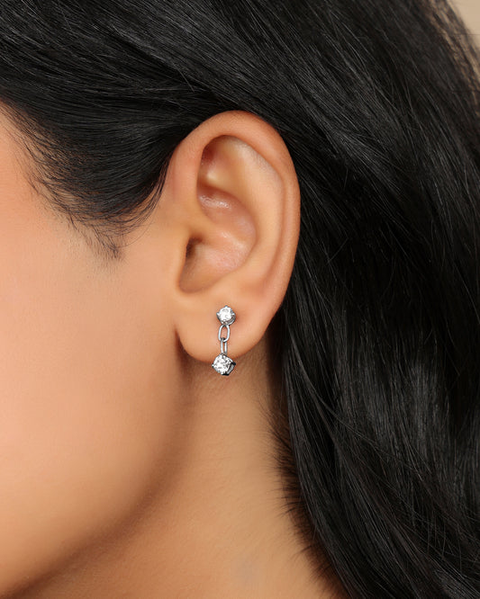 Woman wearing a Nadora Nove double diamond drop earring with two round prong-set stones