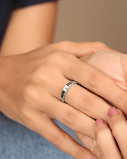 Hand wearing a Nadora Nove emerald-cut diamond band ring, resting on another hand